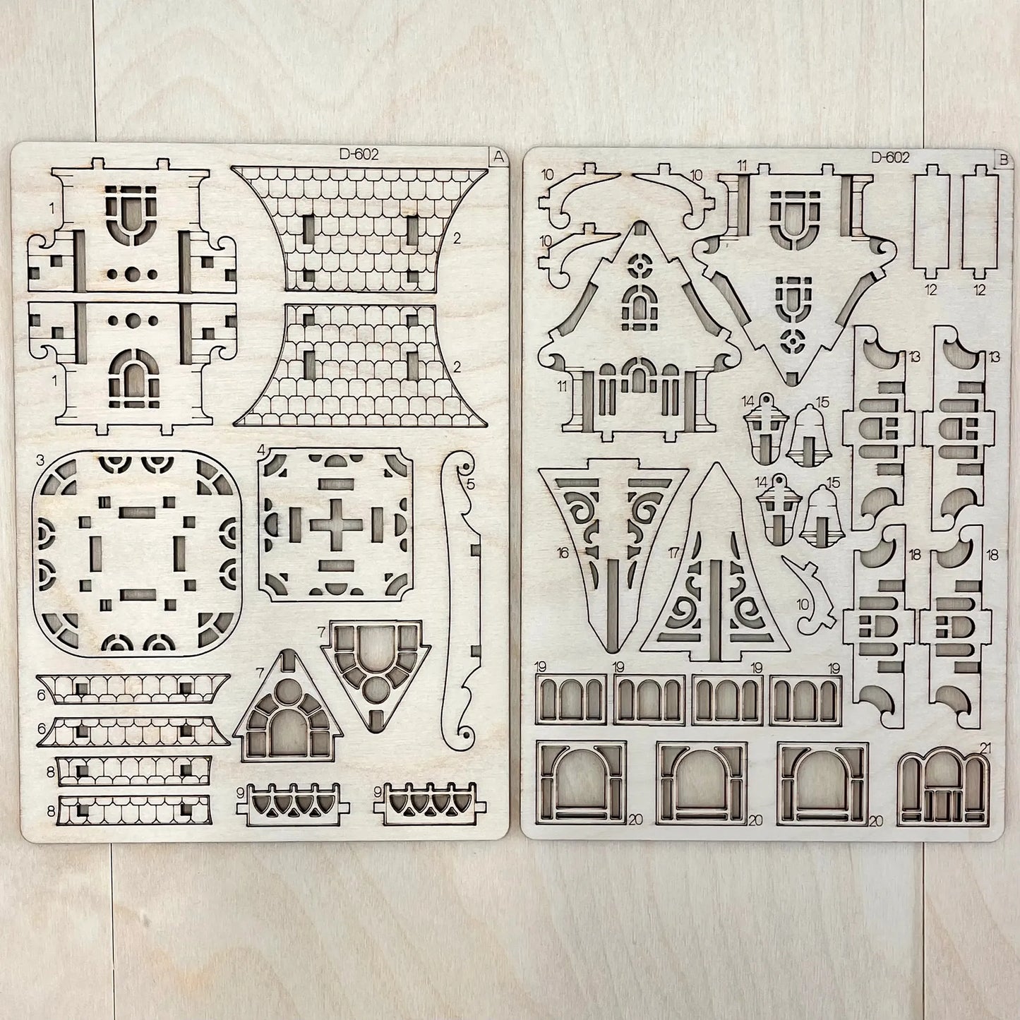 Two house design templates on a wooden surface
