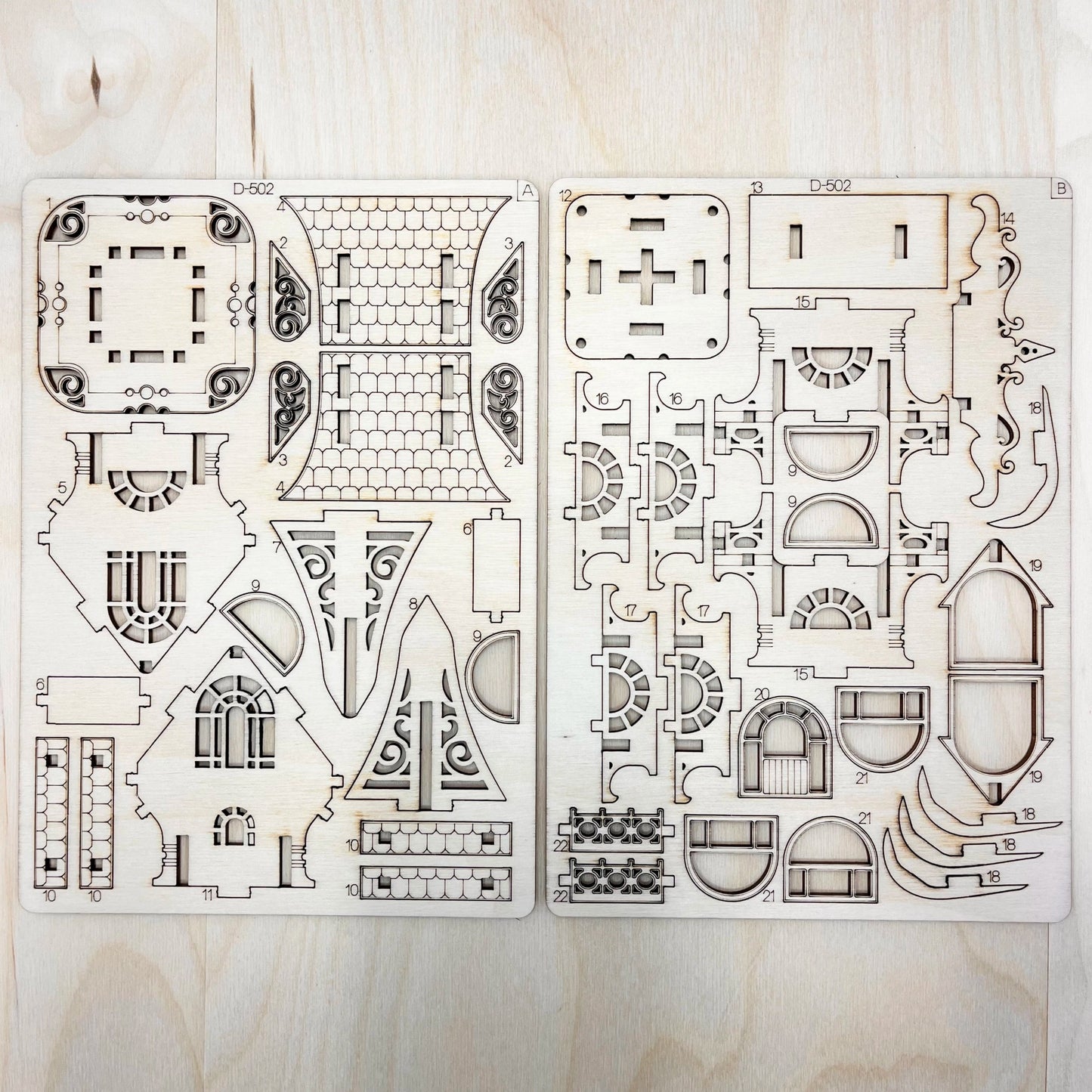 Two sheets of architectural floor plans on a wooden surface