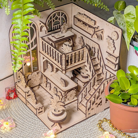Wooden book nook model with intricate details on a decorative surface with plants.