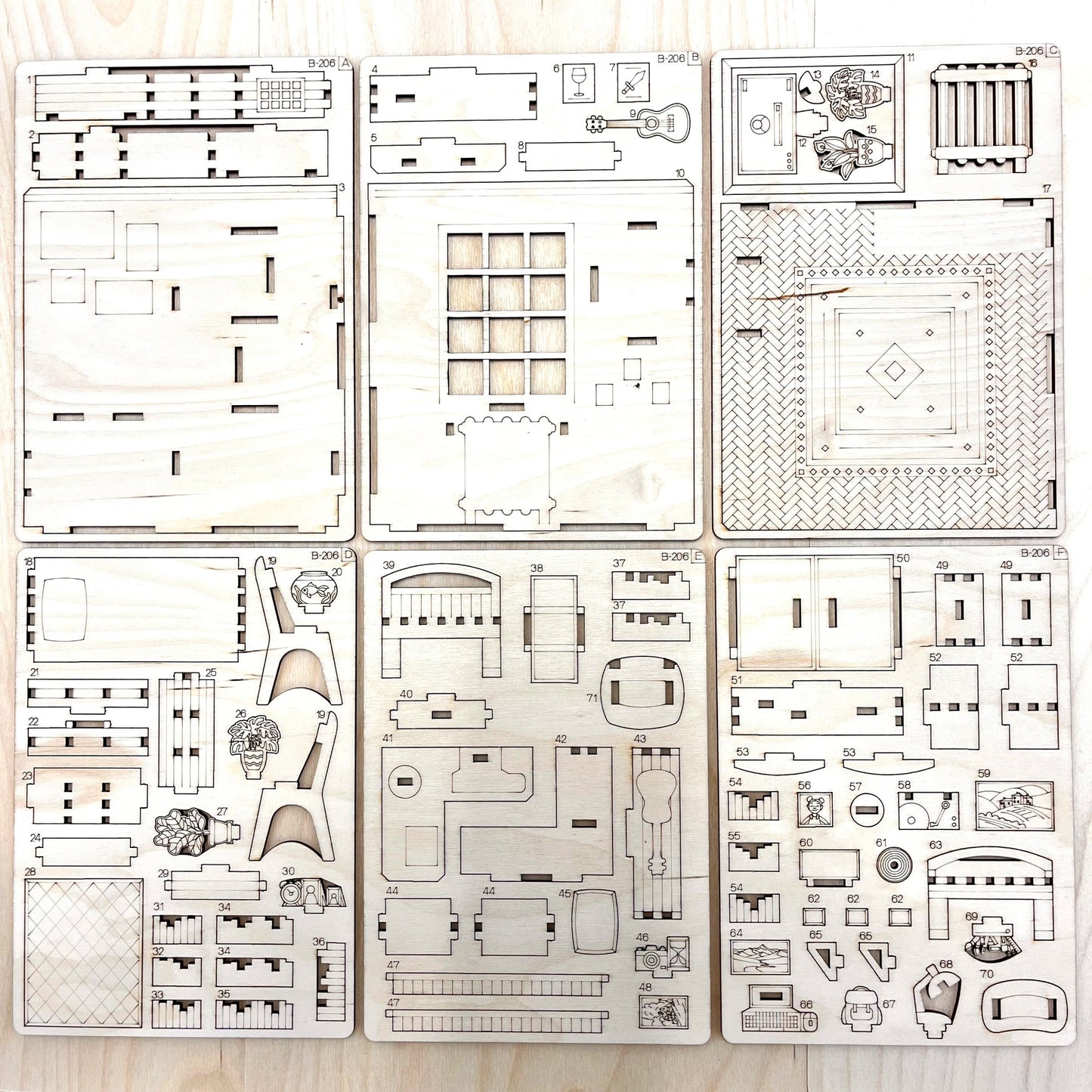Set of laser-cut book nook model parts on a wooden surface