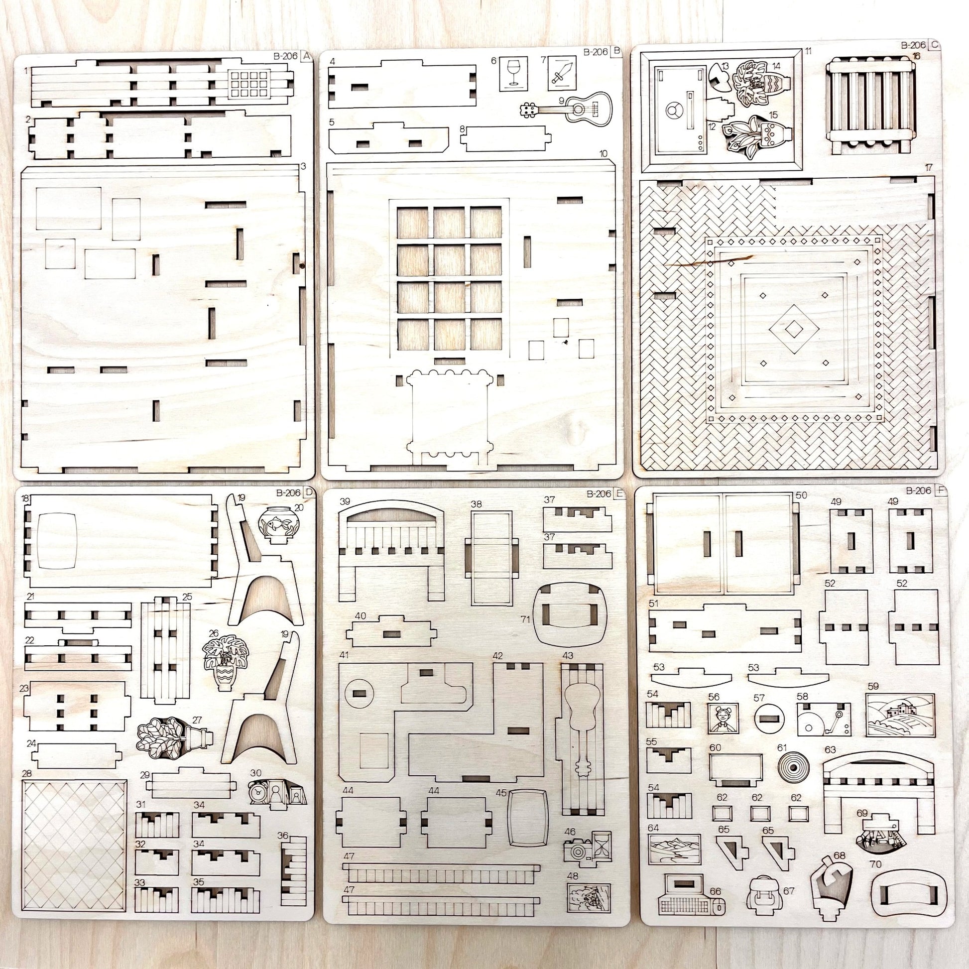 Set of laser-cut book nook model parts on a wooden surface