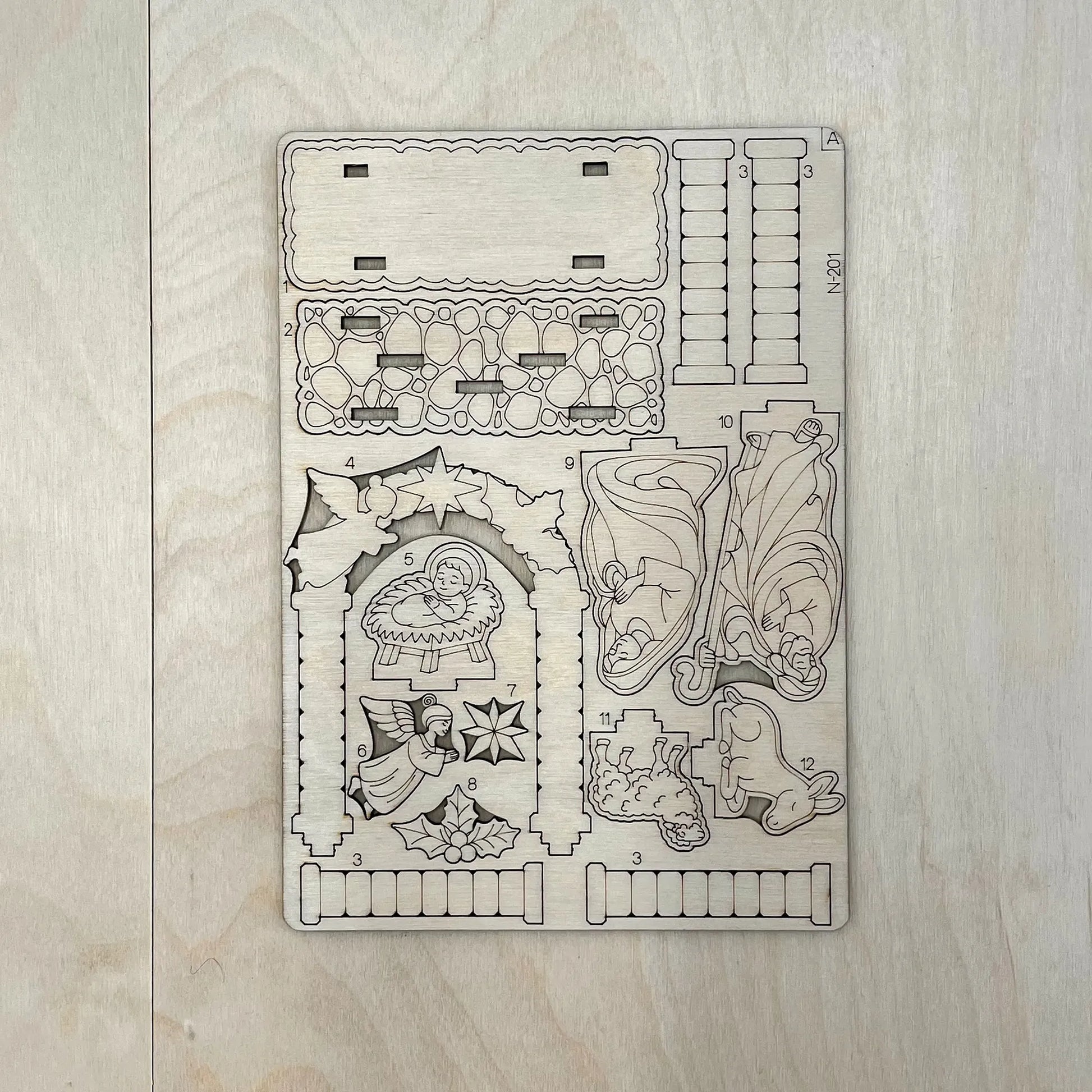 Decorative wooden template with Christmas-themed cutouts on a wooden surface