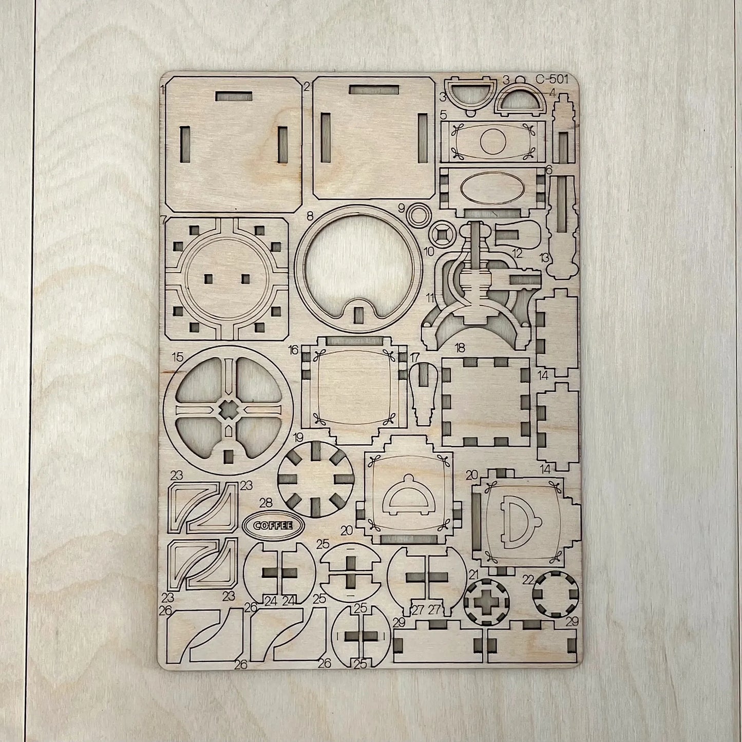 The coffee grinder model parts on a wooden surface