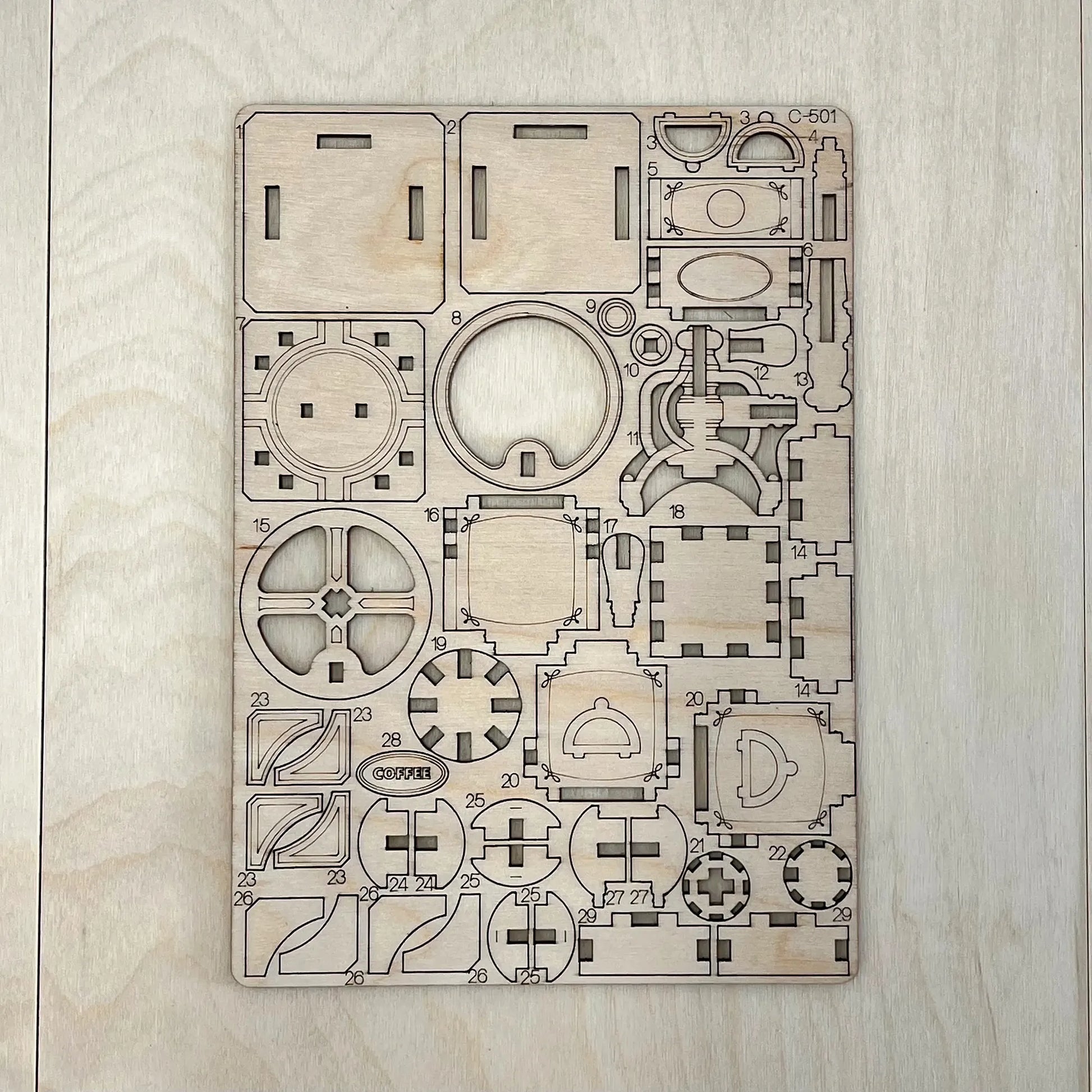 The coffee grinder model parts on a wooden surface