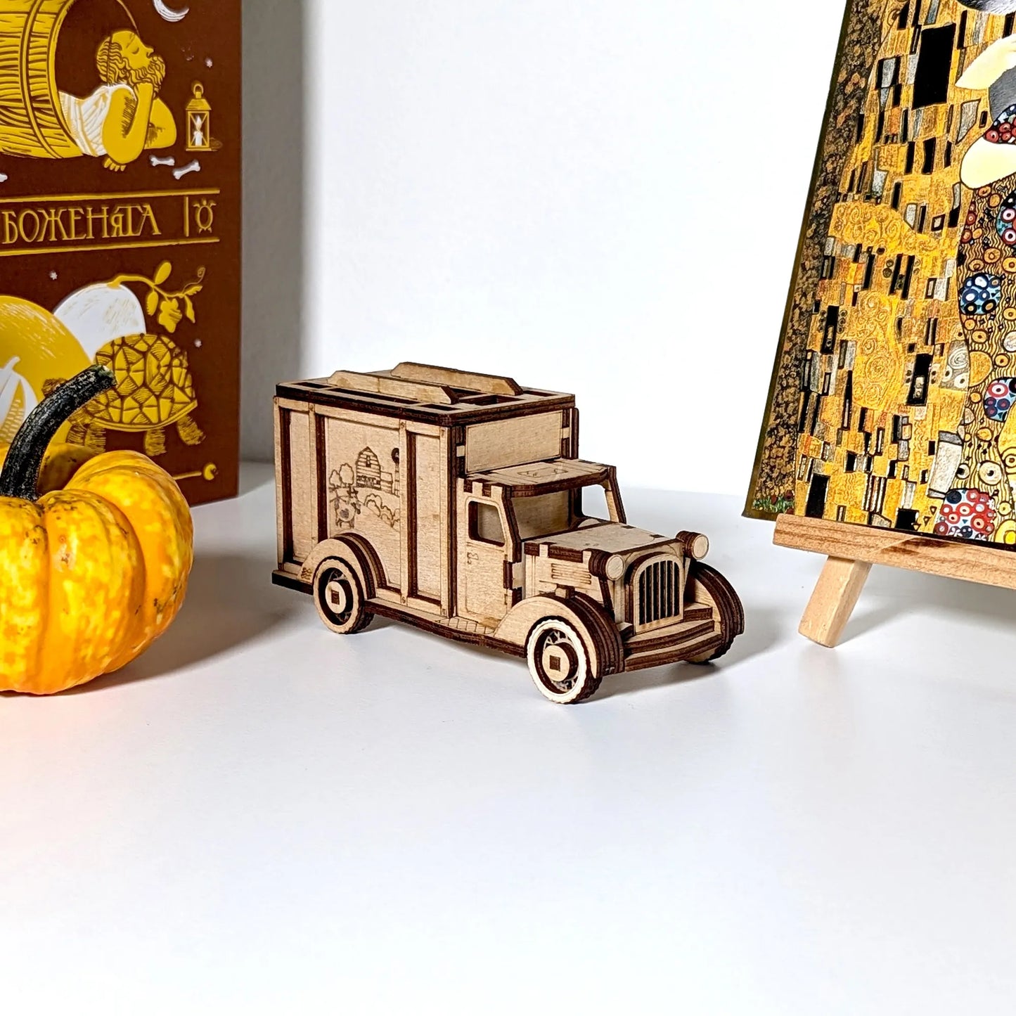 Wooden model of a truck with decorative elements on a white surface