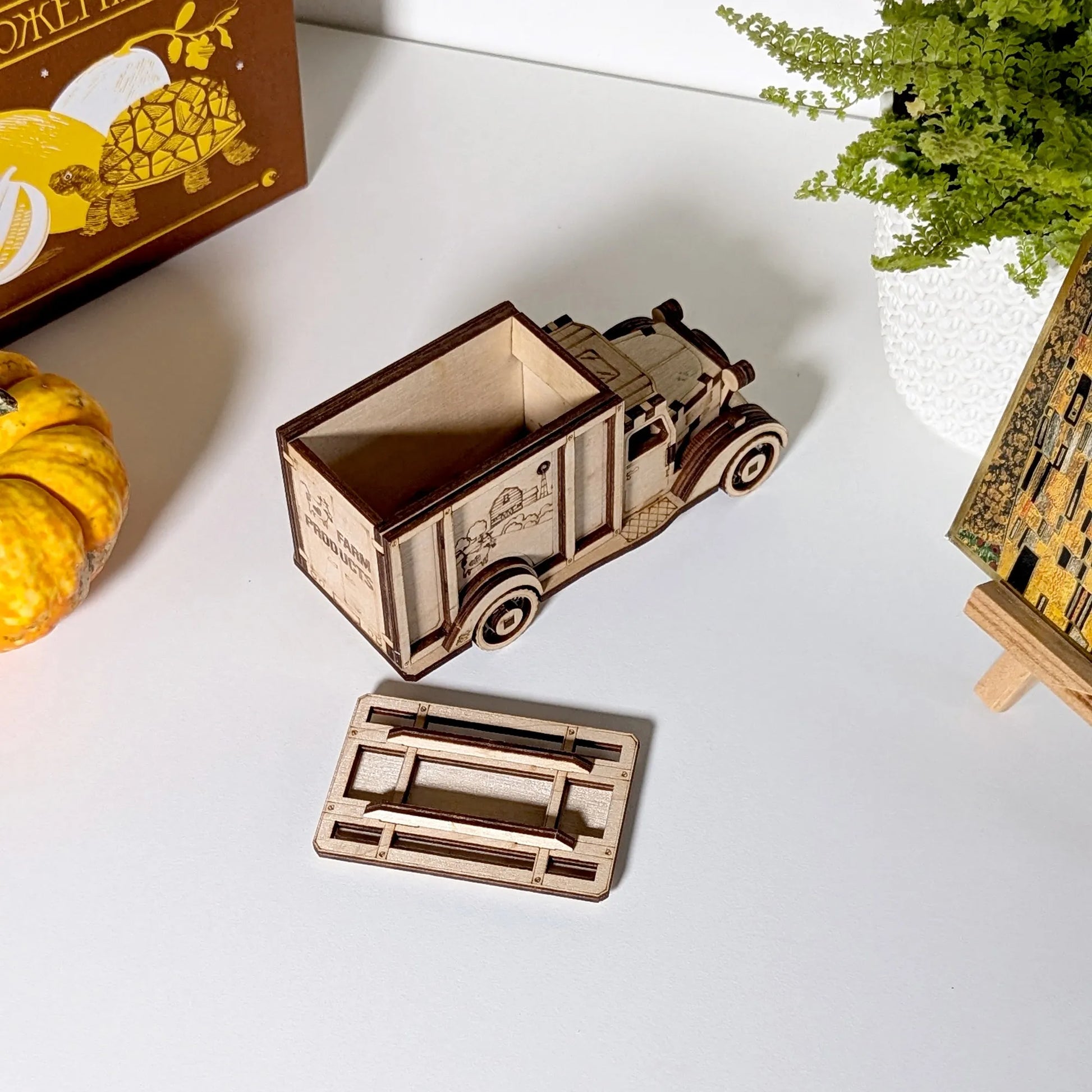 Wooden model of a truck on a white surface with decorative items around