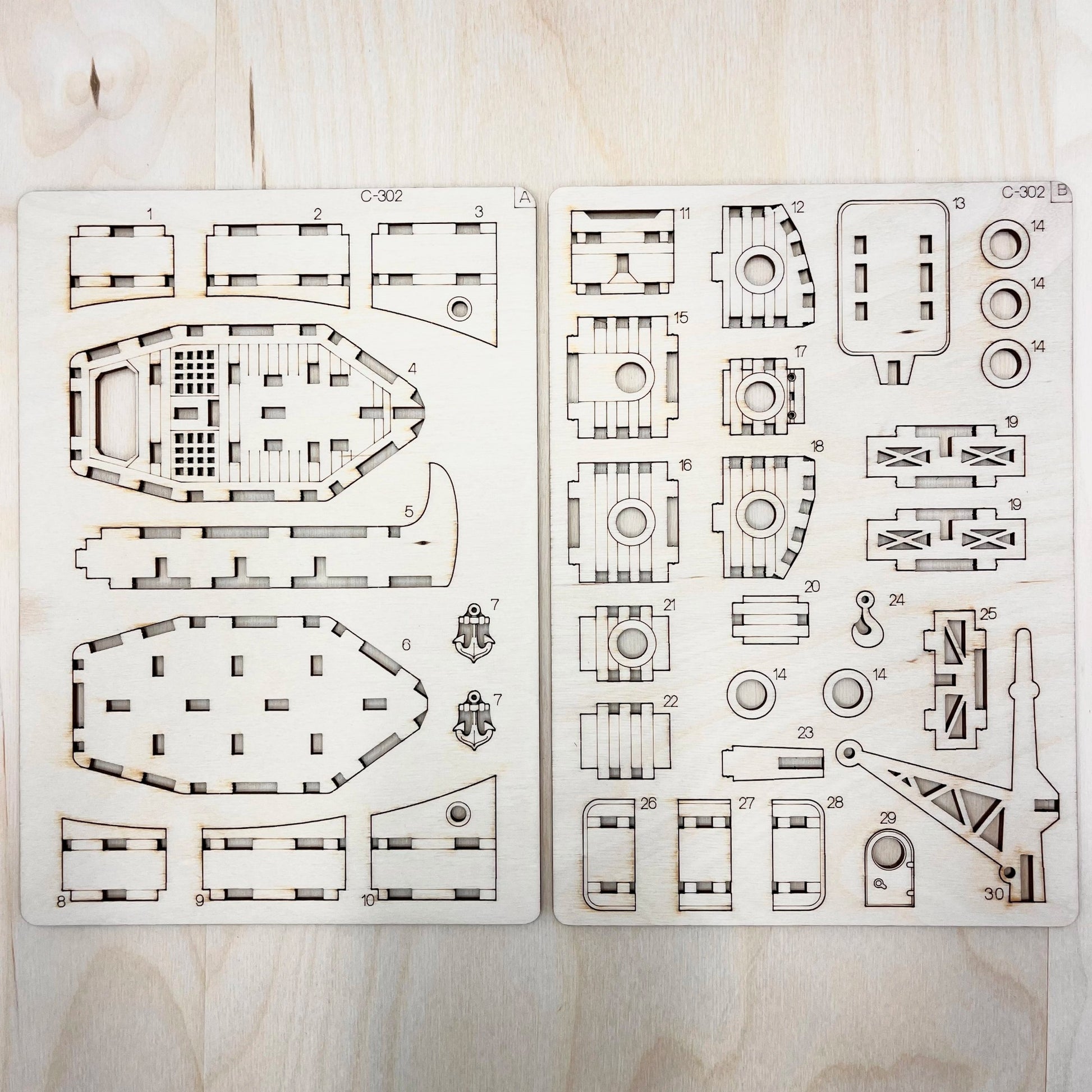 Set of laser-cut ship model parts on a wooden surface