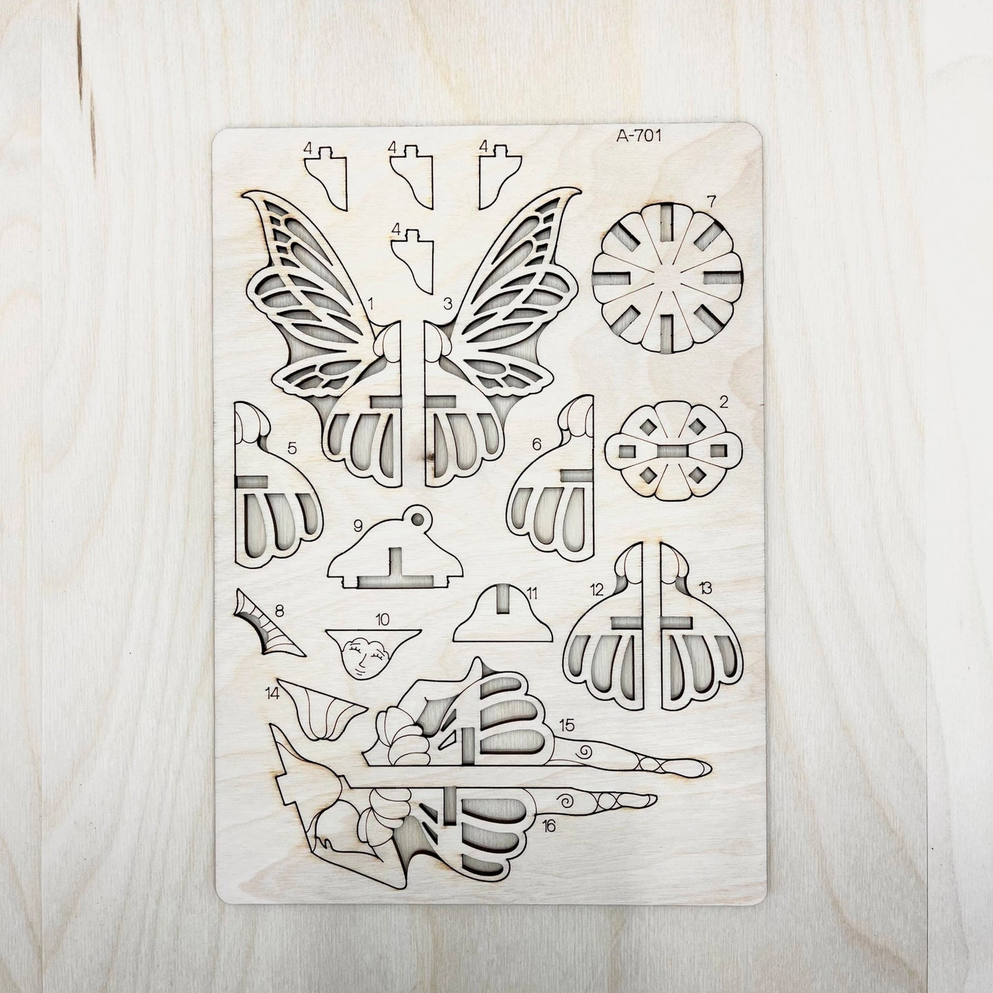wooden cut shapes including butterfly and floral designs on a wooden surface
