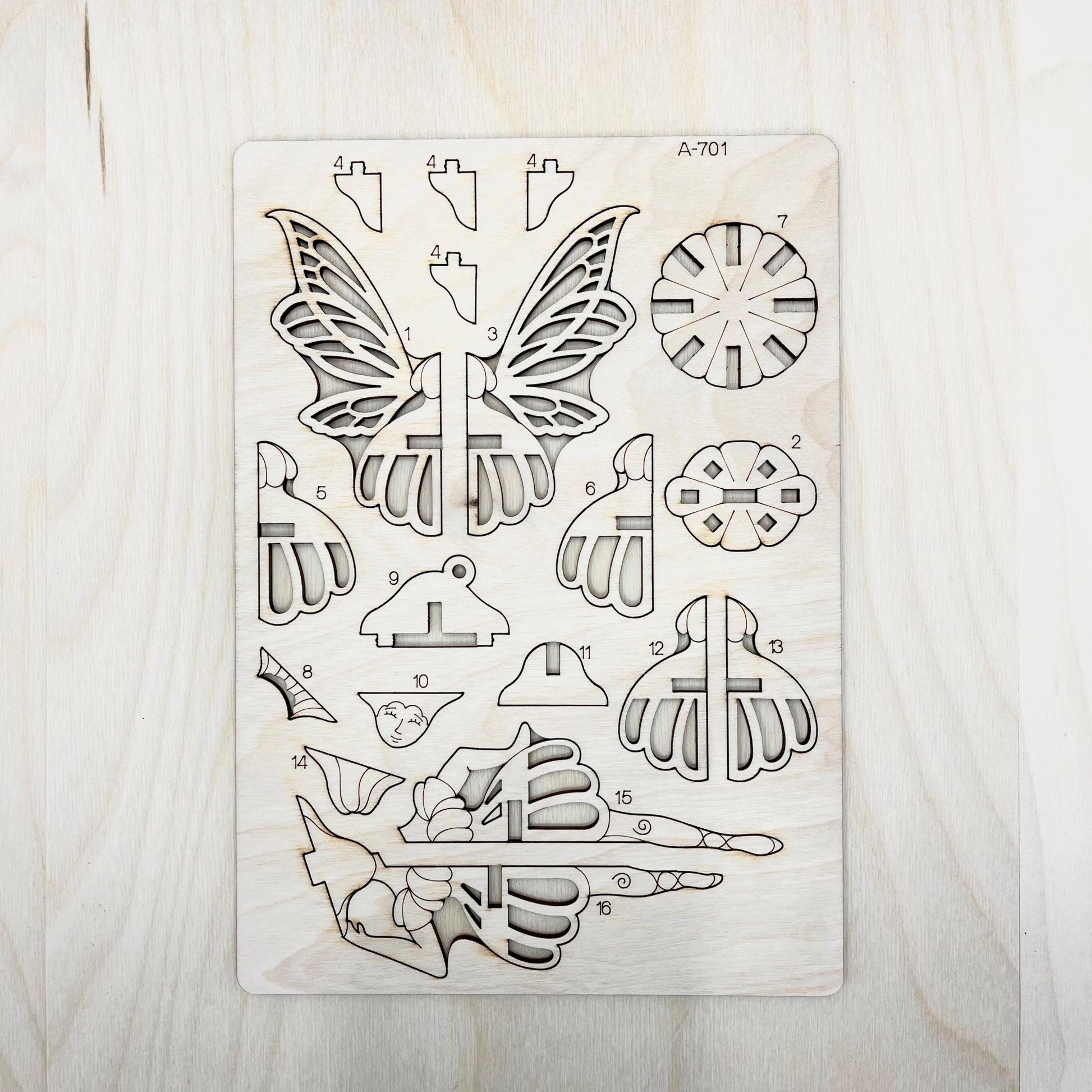 wooden cut shapes including butterfly and floral designs on a wooden surface
