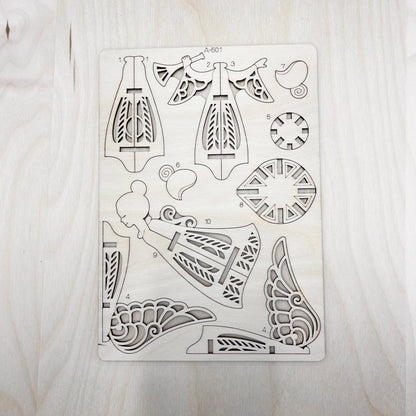 Set of laser-cut angel model parts on a wooden surface