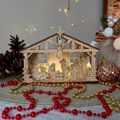 Wooden nativity scene with lights surrounded by red and gold beads on a textured surface.