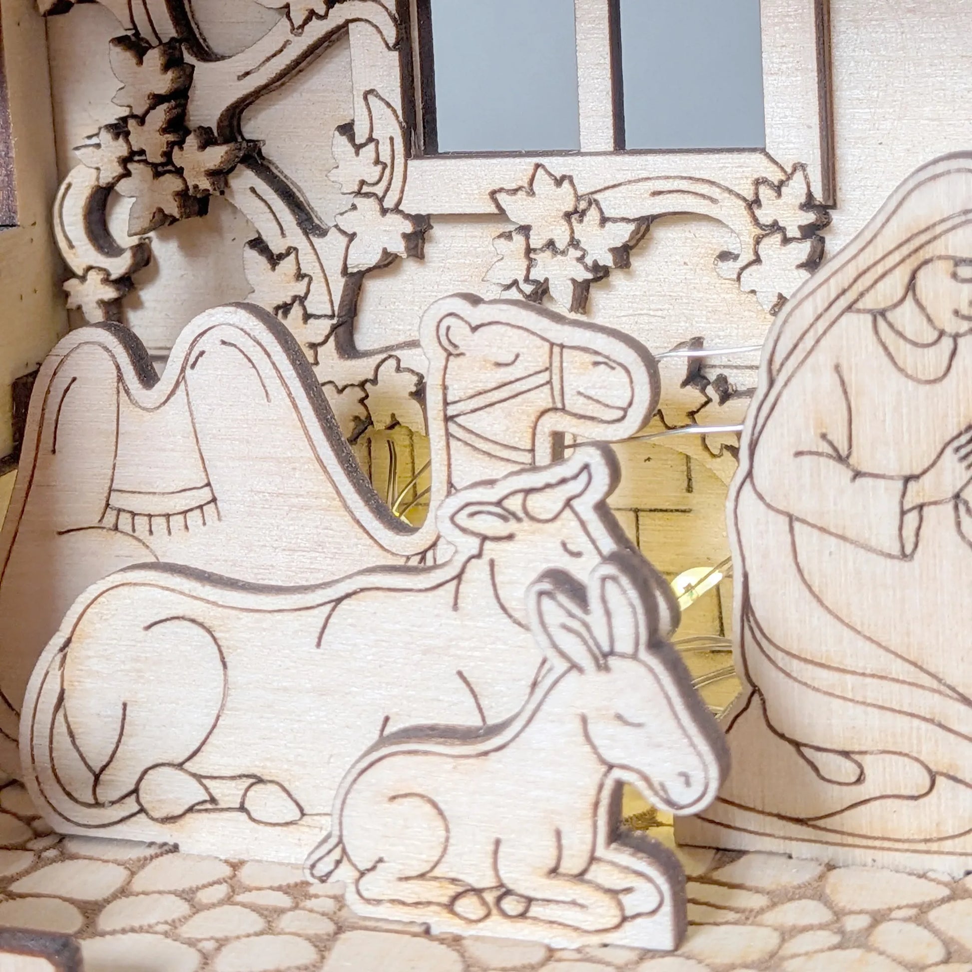 Wooden nativity scene with Mary, Joseph, and baby Jesus in a manger.