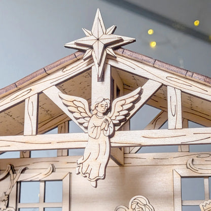 Wooden nativity scene with angel and star on a clear sky background