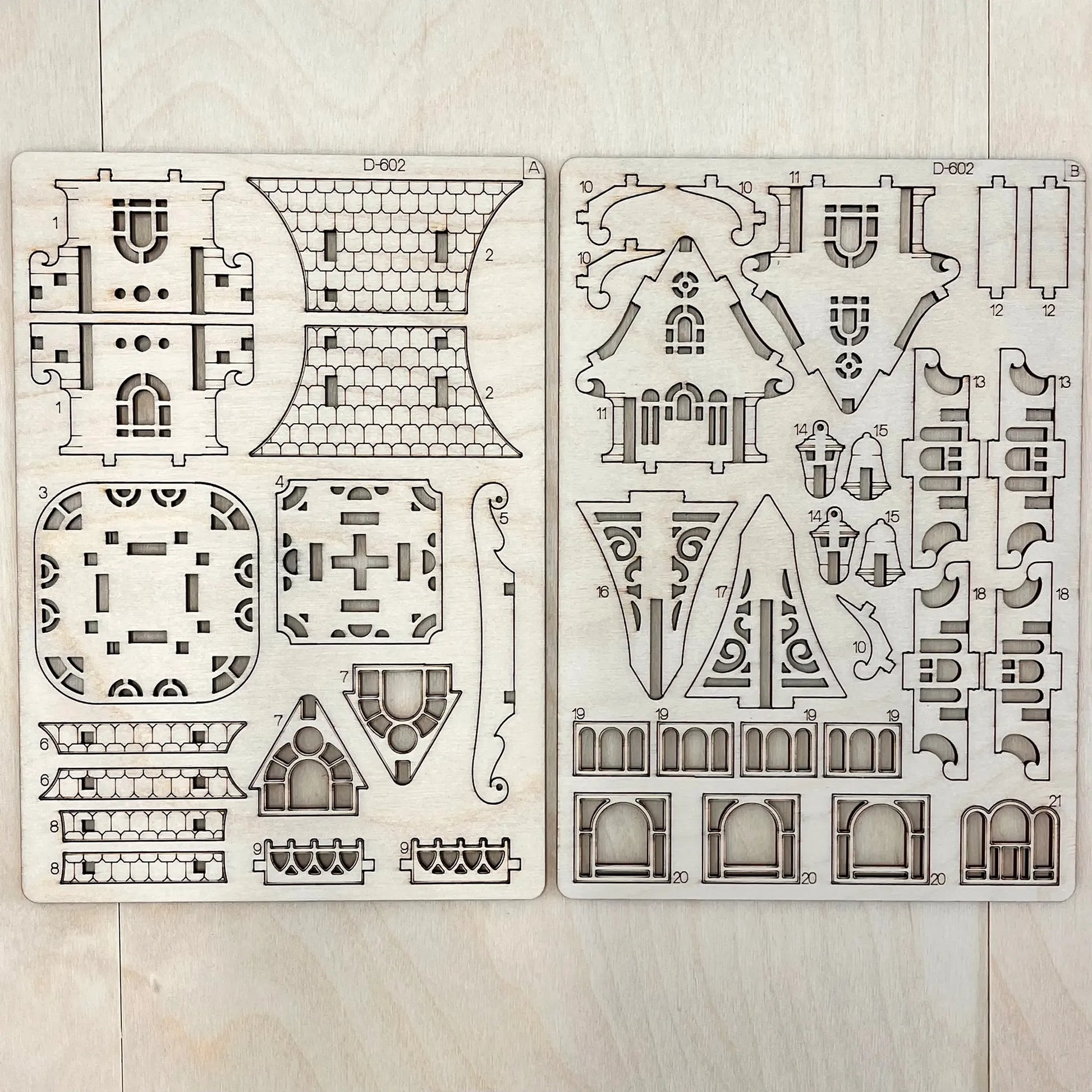 Two house design templates on a wooden surface