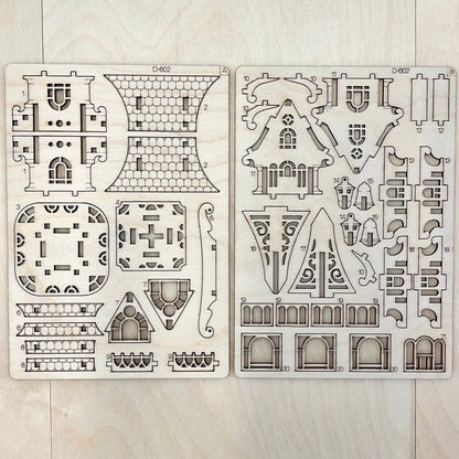 Two house design templates on a wooden surface