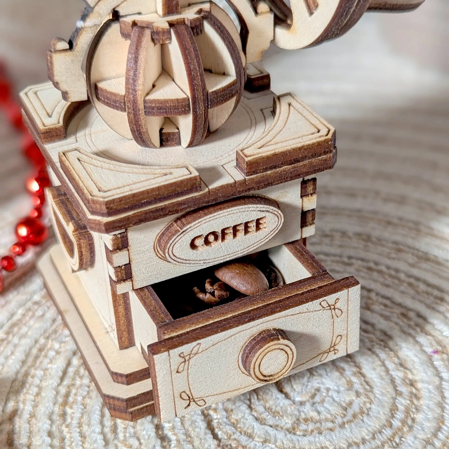 Wooden coffee grinder model with 'COFFEE' text on a textured surface
