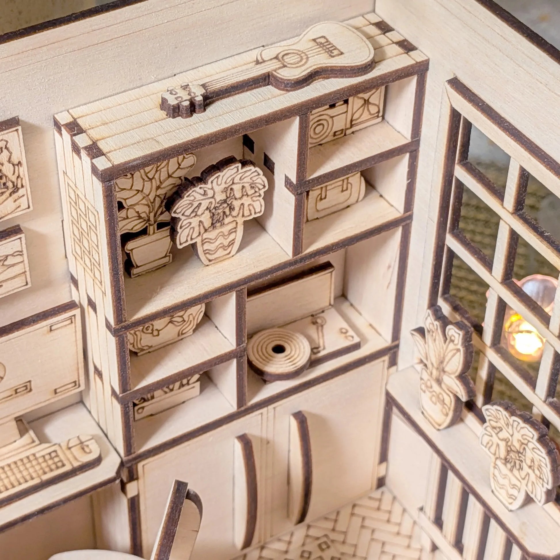 Wooden model of a room with shelves and decorative items