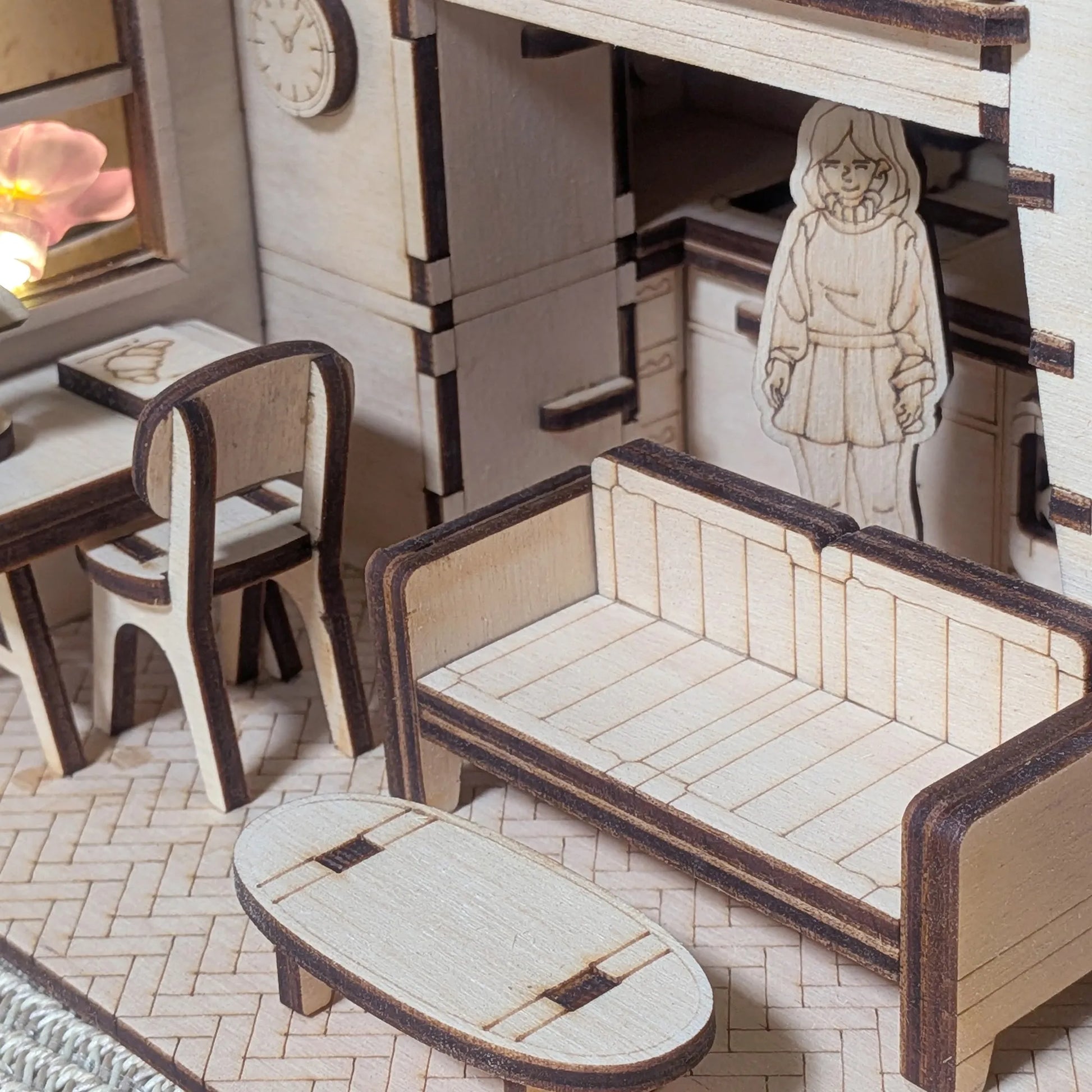 Wooden dollhouse furniture set with a small figure inside, including a bed, chair, and table.