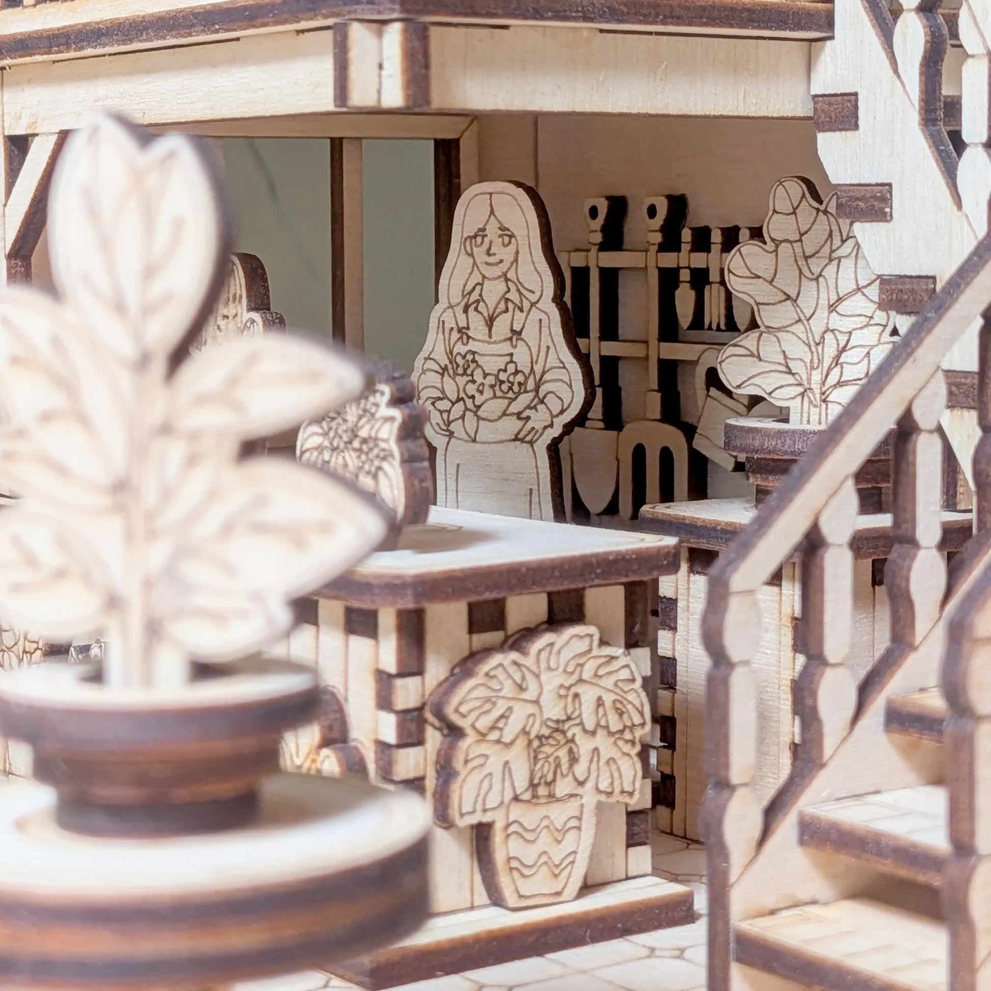 Wooden book nook model with cut-out figures and plants