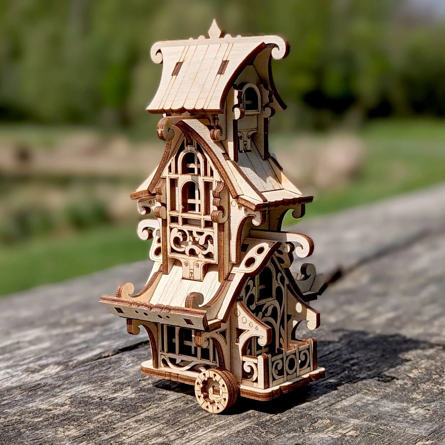 Wooden model of a detailed building on a wooden surface with a blurred natural background