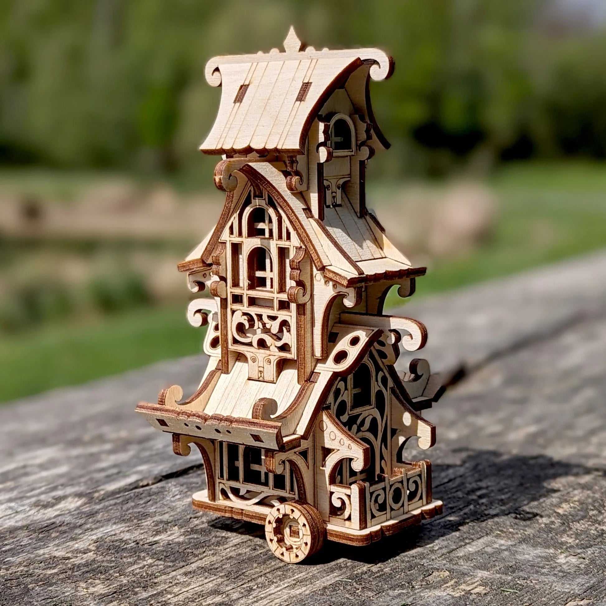 Wooden model of a detailed building on a wooden surface with a blurred natural background