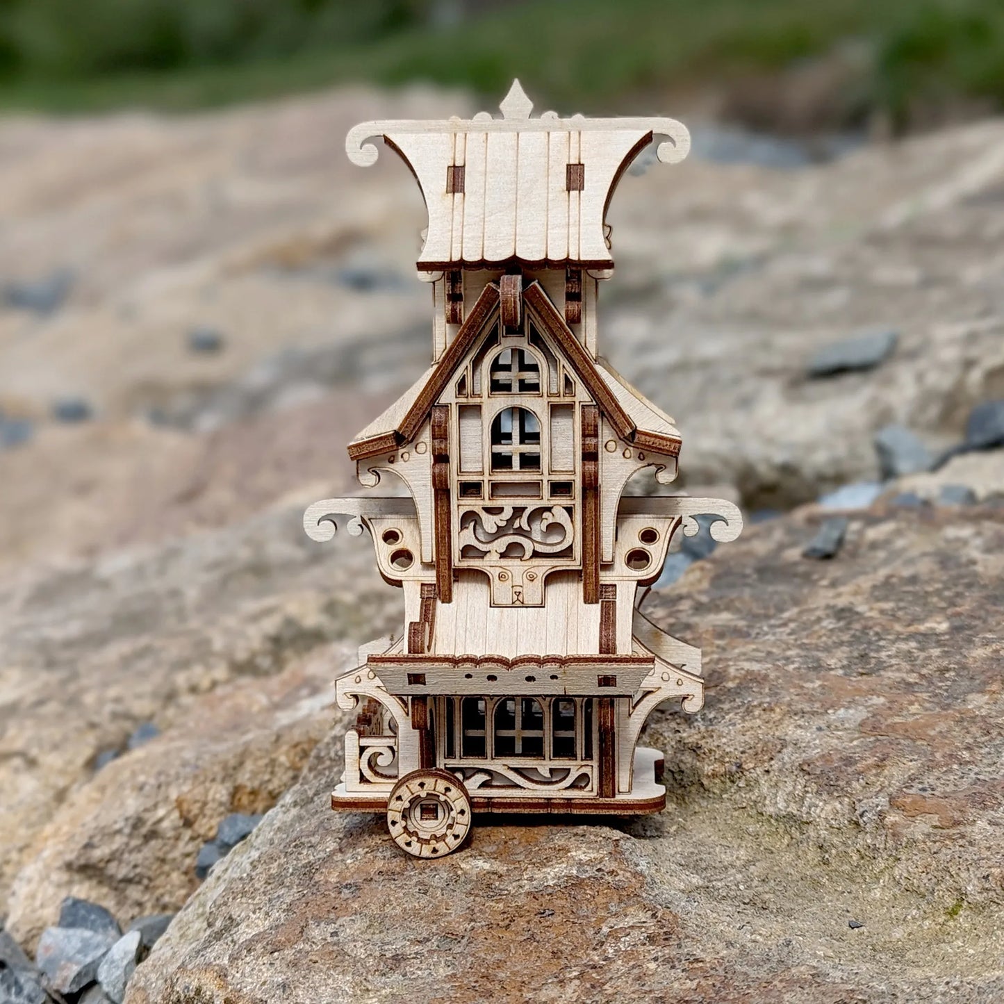 Wooden model of a decorative building on a rocky surface