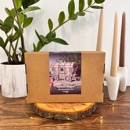 Cardboard box with a twiglio product on a wooden surface with candles and a plant in the background