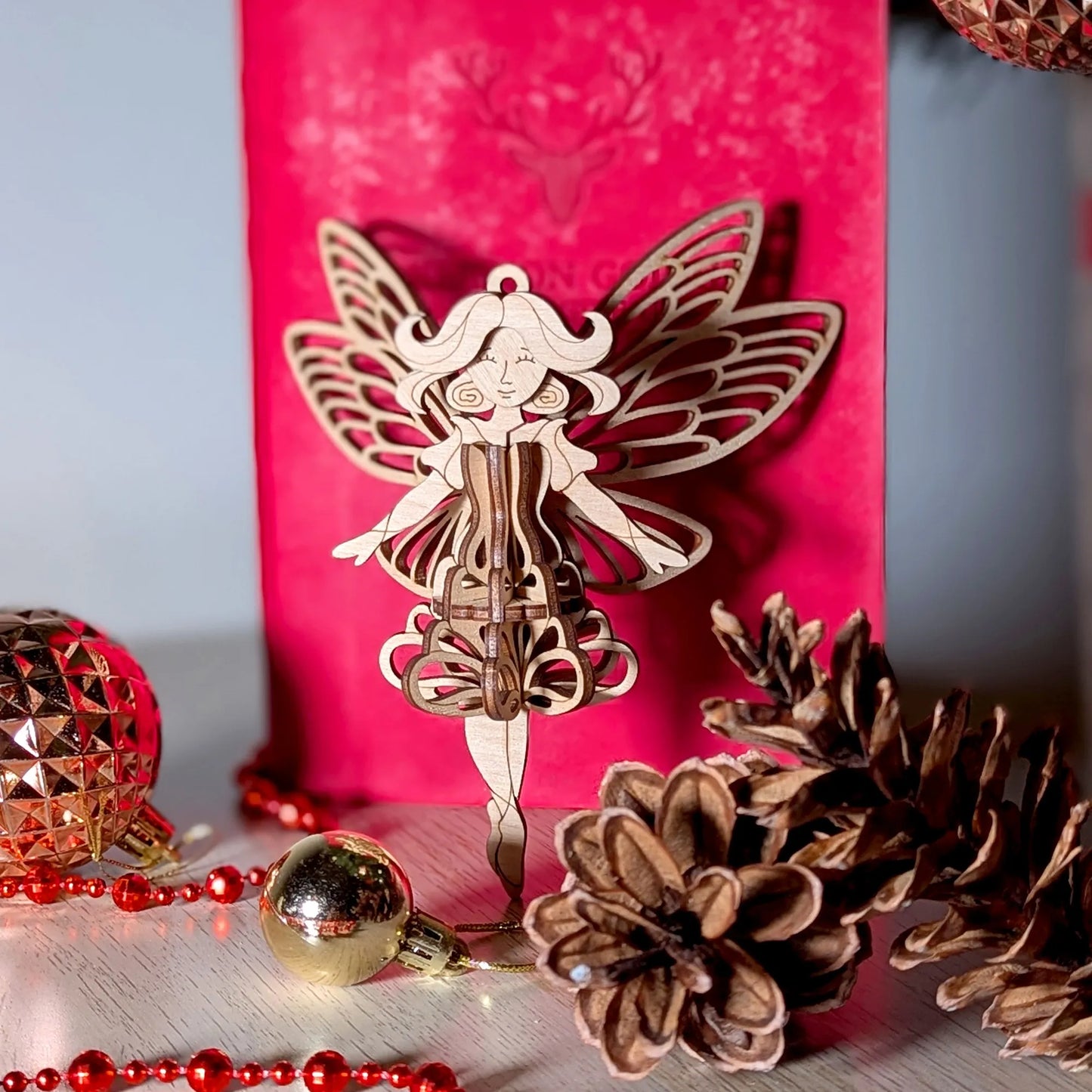 Decorative fairy figure with a pink background and festive elements.