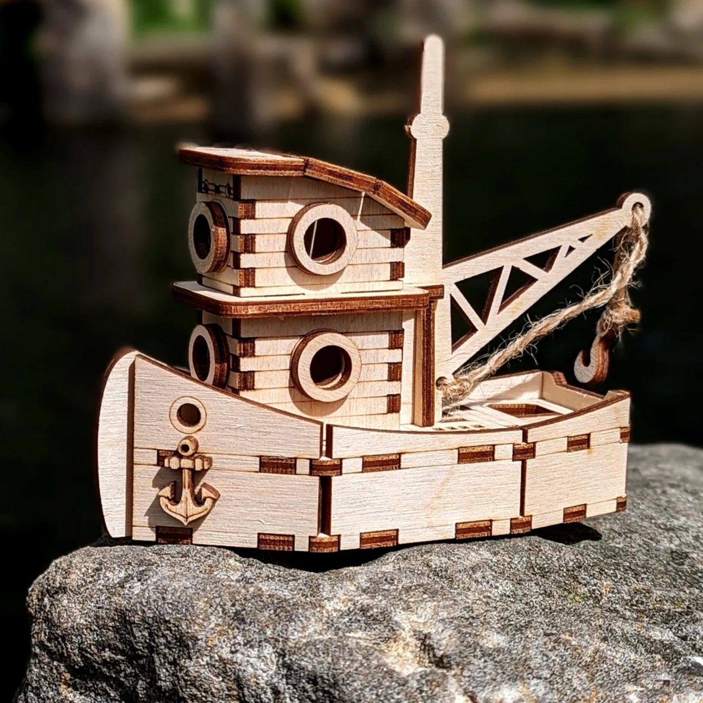 Wooden toy boat on a rock with a natural background