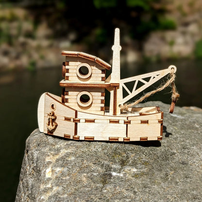 Wooden toy boat with crane on a rock by a body of water