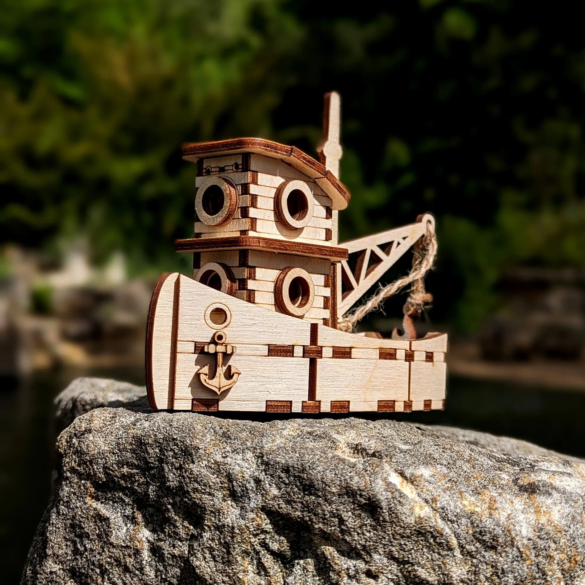 Wooden toy ship on a rock with a blurred natural background