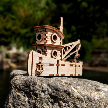 Wooden toy ship on a rock with a blurred natural background