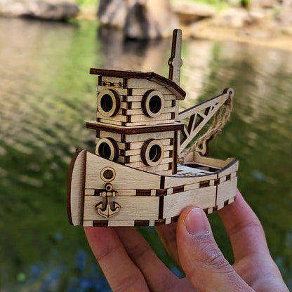 Wooden toy boat model held by a hand with a blurred natural background