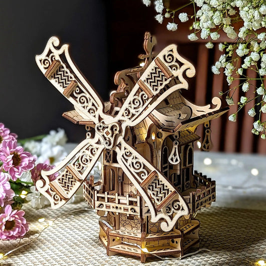 Wooden windmill model with decorative elements on a textured surface with flowers.