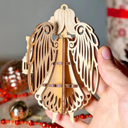 Wooden angel ornament held in a hand with Christmas decorations in the background