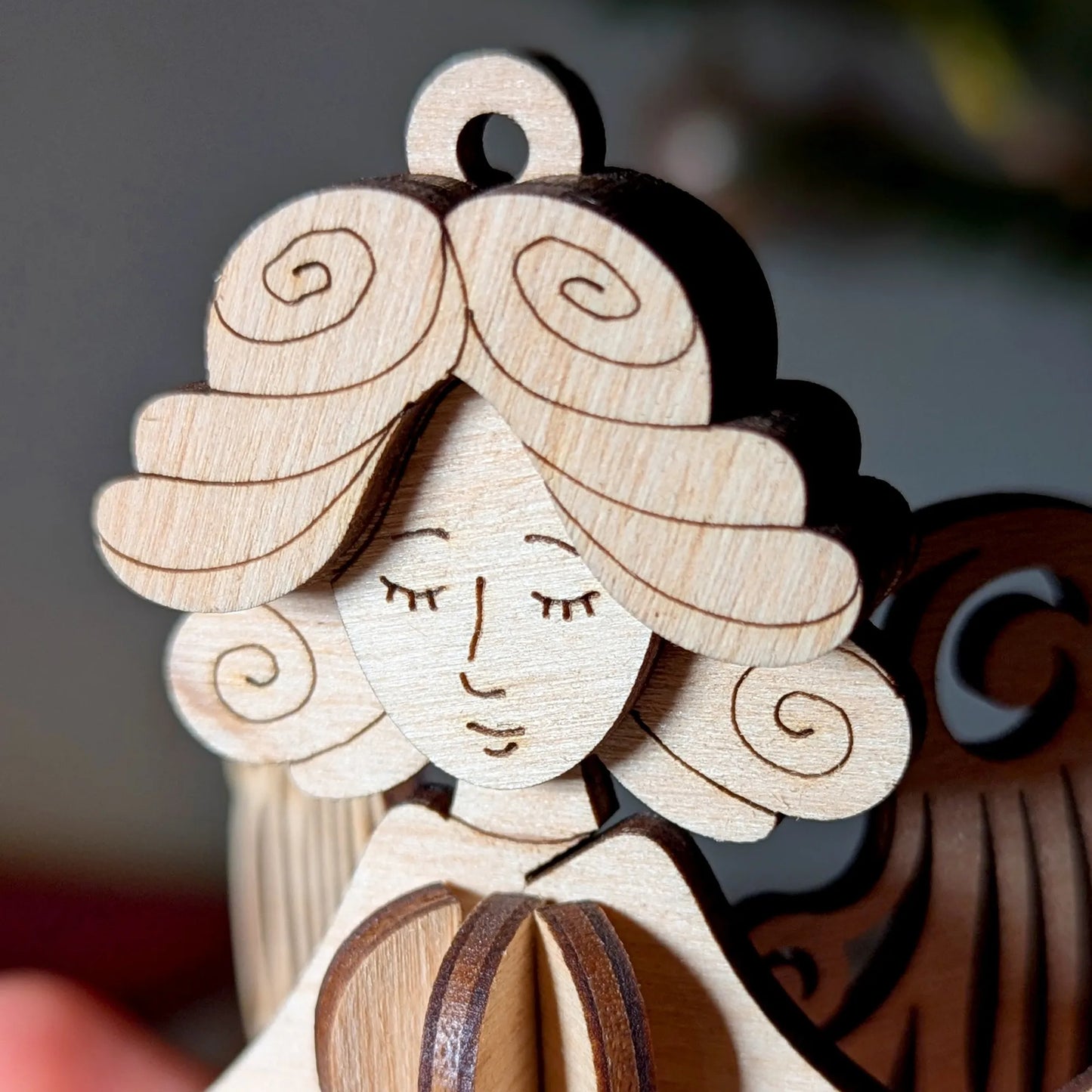 Wooden ornament of a girl with a heart, close-up on a blurred background