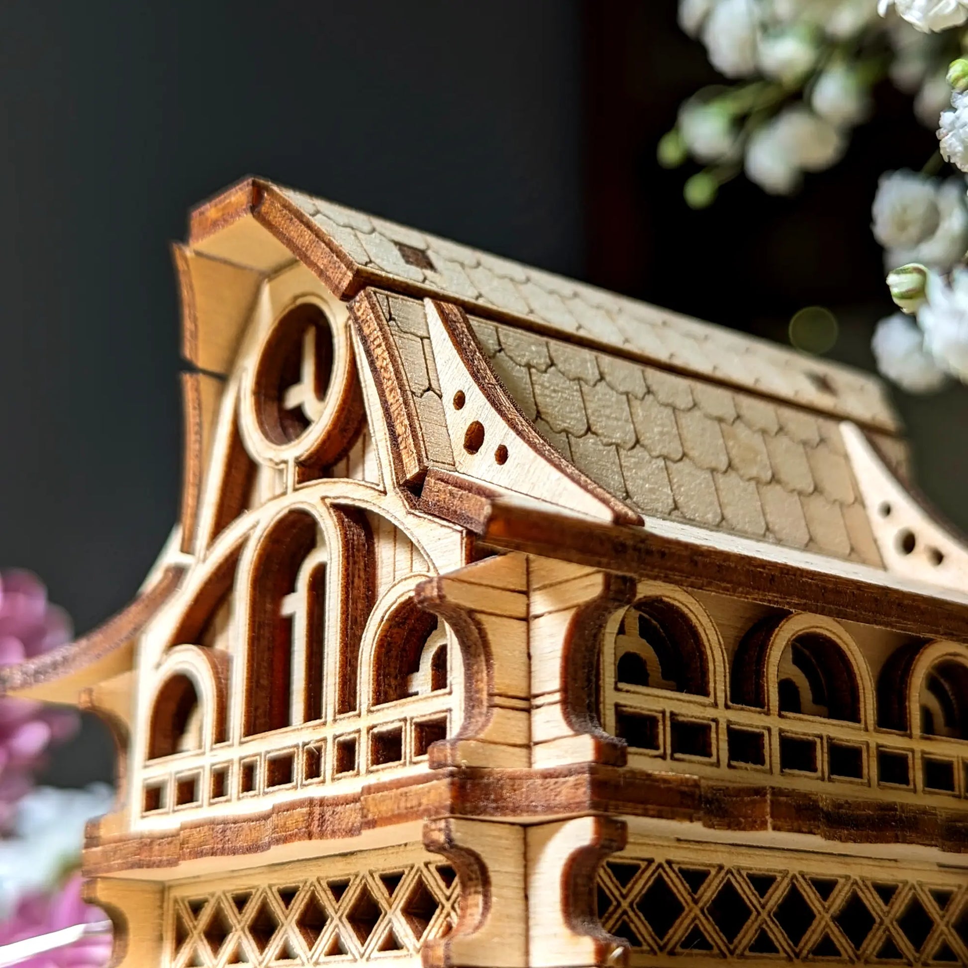 Wooden architectural model with intricate details on a dark background