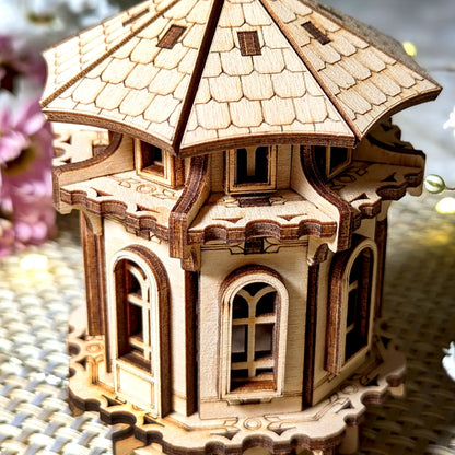 Wooden model of a tower with decorative flowers on a textured surface