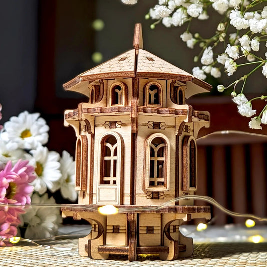 Wooden model of a building with decorative flowers on a textured surface